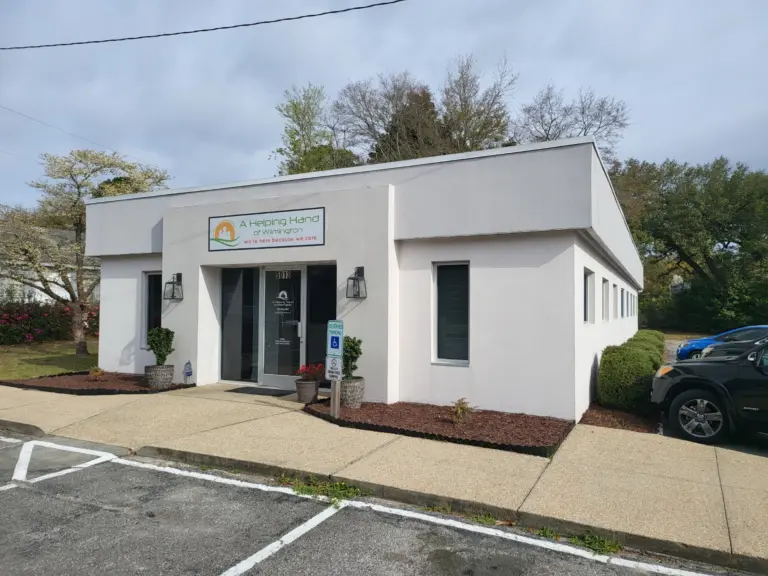 White stucco building with an A Helping Hand of Wilmington sign above the entrance