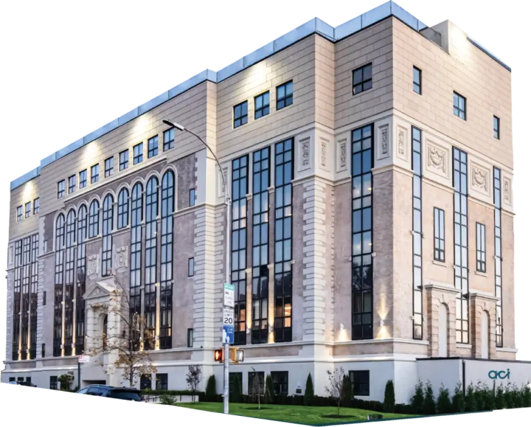 Multi-story building with cream stone facade and tall windows, with an aci sign near the lower right corner