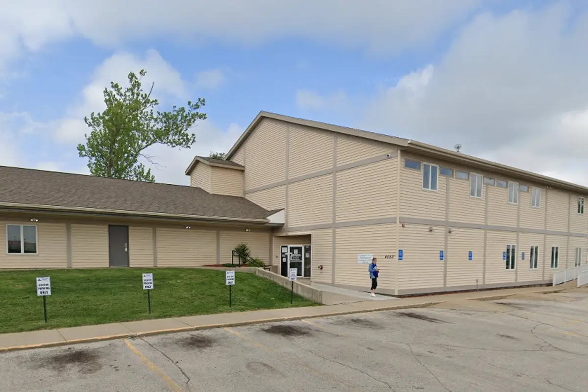Two-story beige building with a parking lot and entrance