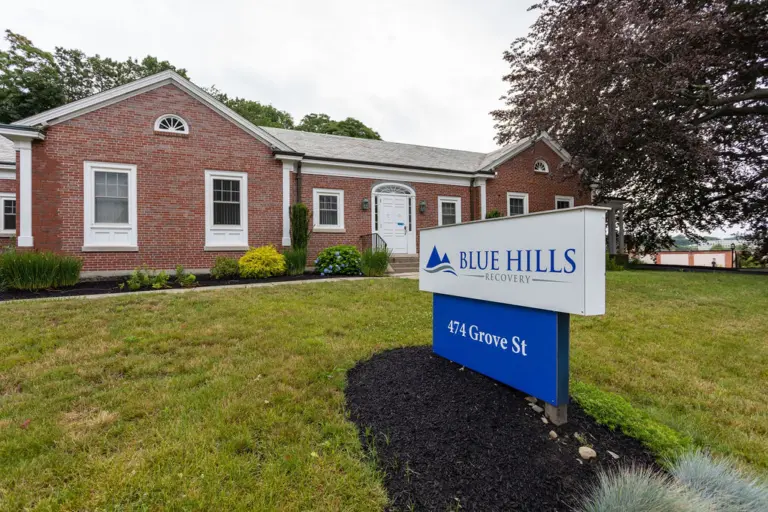 Two-story brick building with a Blue Hills Recovery sign reading 474 Grove St