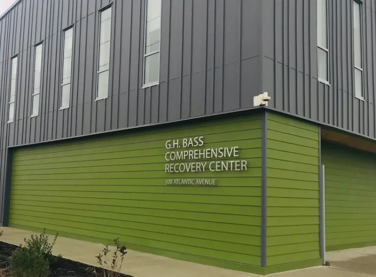 Corner of the G.H. Bass Comprehensive Recovery Center building with green and gray siding at 508 Atlantic Avenue