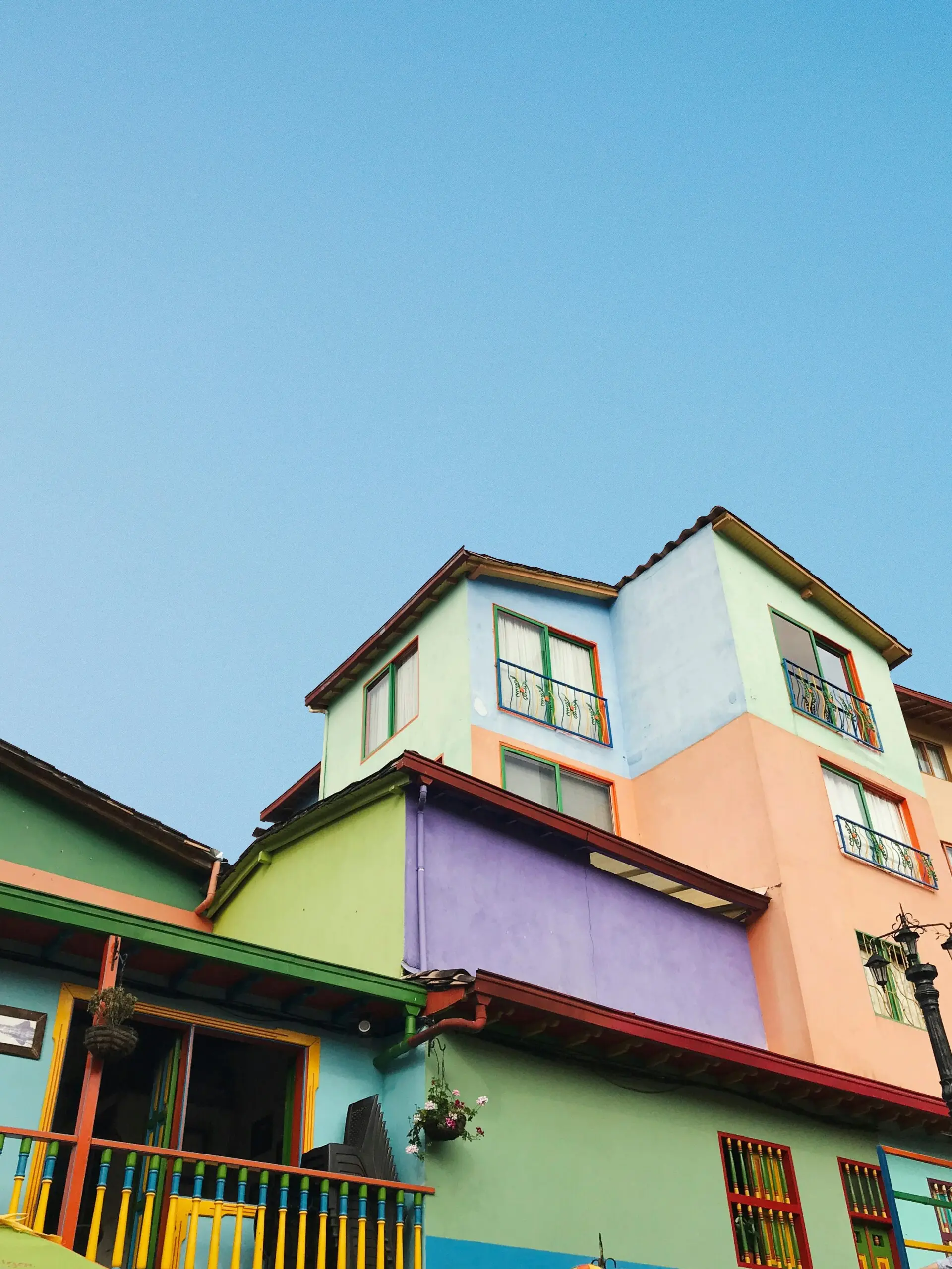 Multi-story building with colorful pastel facades under a clear blue sky