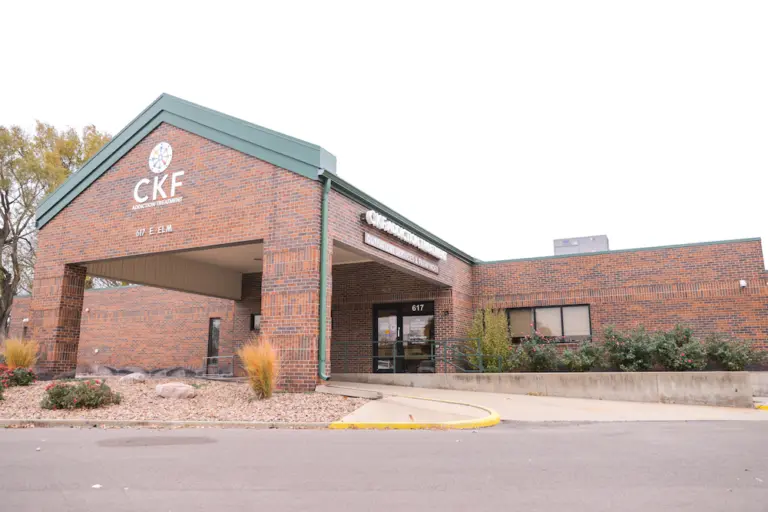 Two-story brick building with a CKF Addiction Treatment sign and 617 E. Elm address