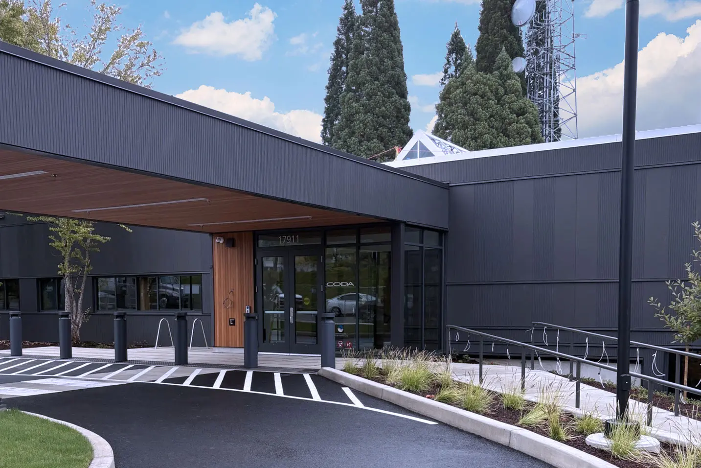 Modern dark-gray CODA building entrance with covered walkway and address 17911 above the doors