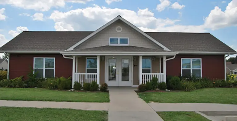 One-story brick and siding building with a covered front entrance and lawn