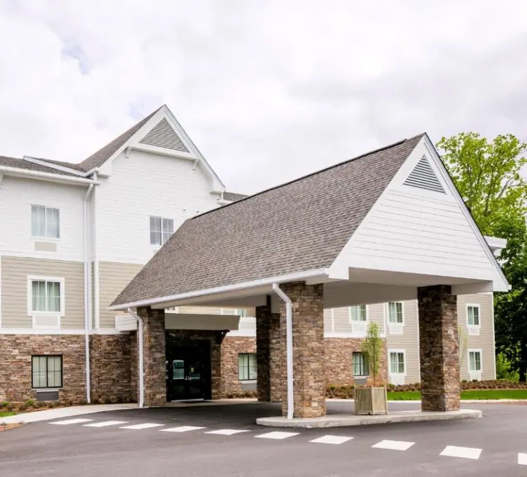 Multi-story building with stone columns and a covered entrance drive