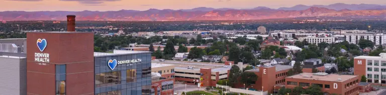 Aerial view of Denver Health campus buildings with Denver Health signage at sunrise