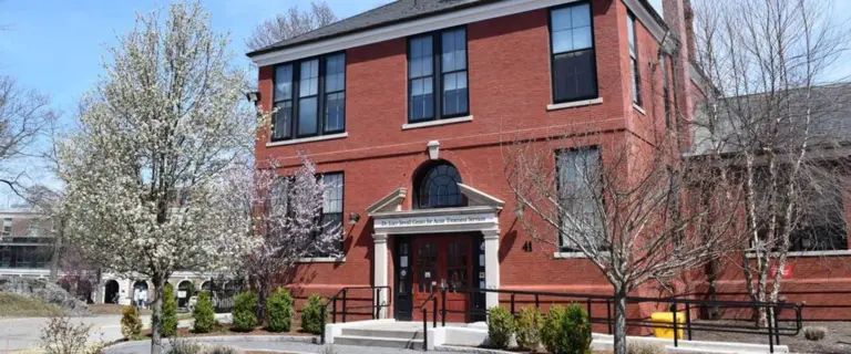 Red brick building with Dr. Lois Sewall Center for Acute Treatment Services sign over the entrance