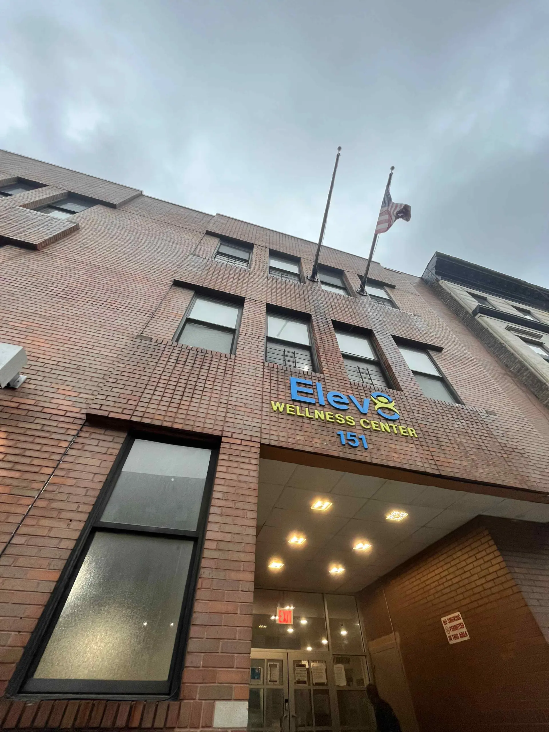 Brick building with an Elev8 Wellness Center sign and the number 151 above the entrance