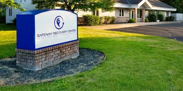 Brick-based Gateway Recovery Center sign on a lawn in front of a single-story building
