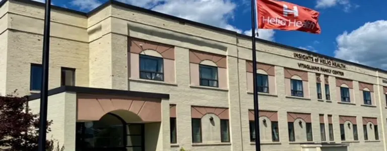Multi-story cream brick building with Insights of Helio Health and Helio Health flag