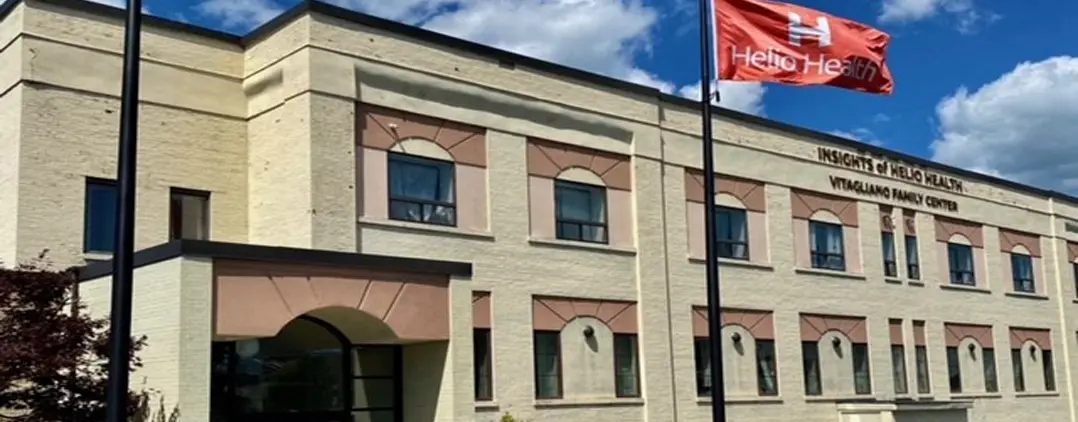 Multi-story cream brick building with Insights of Helio Health and Helio Health flag
