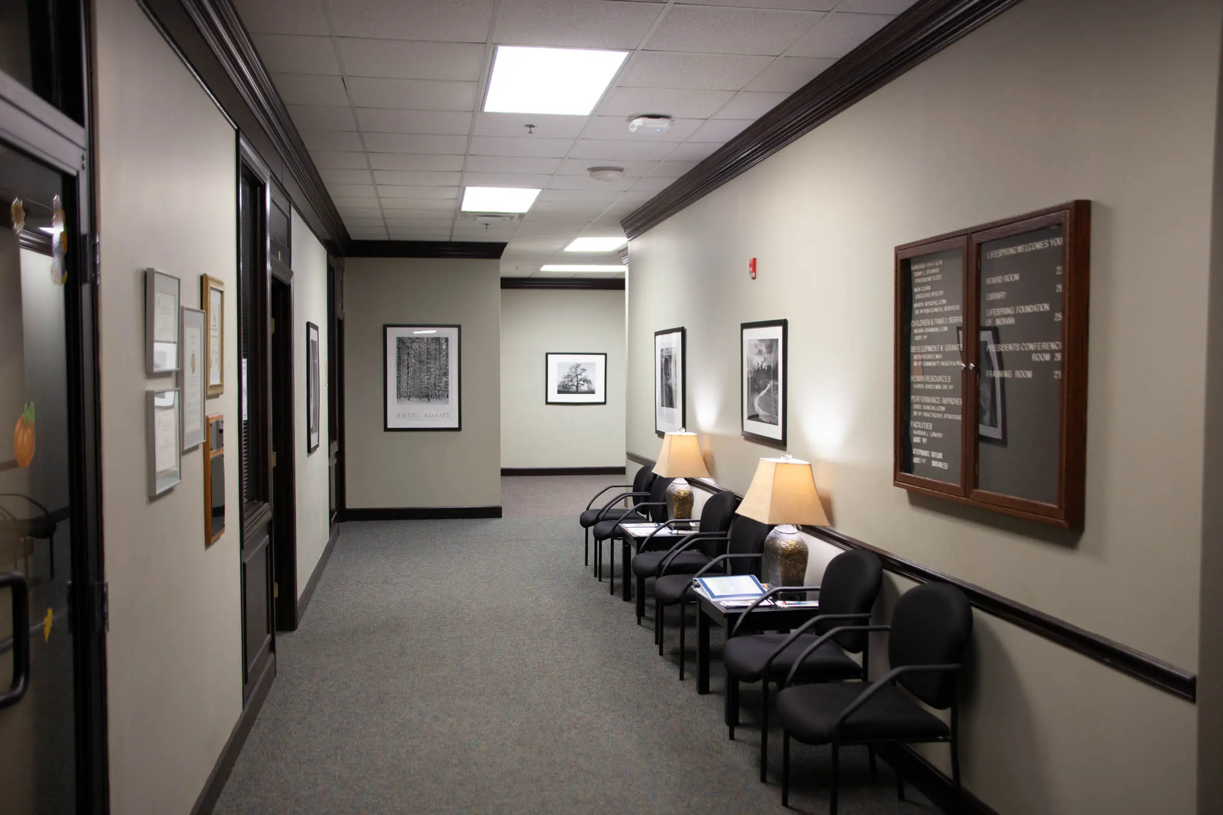 Carpeted hallway with waiting chairs and a wall directory reading LifeSpring Welcomes You
