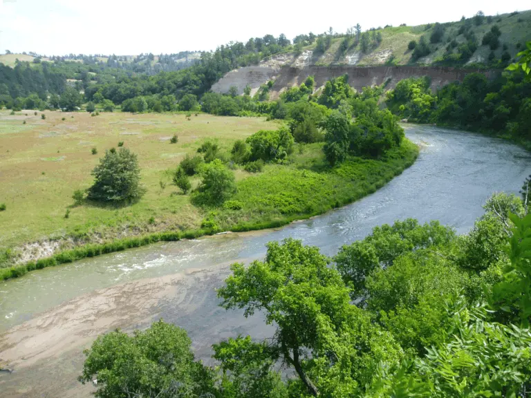 Niobrara River winding through a green valley with grassland and wooded bluffs