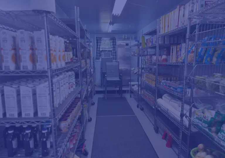 Food pantry shelves stocked with milk cartons, canned goods and packaged food