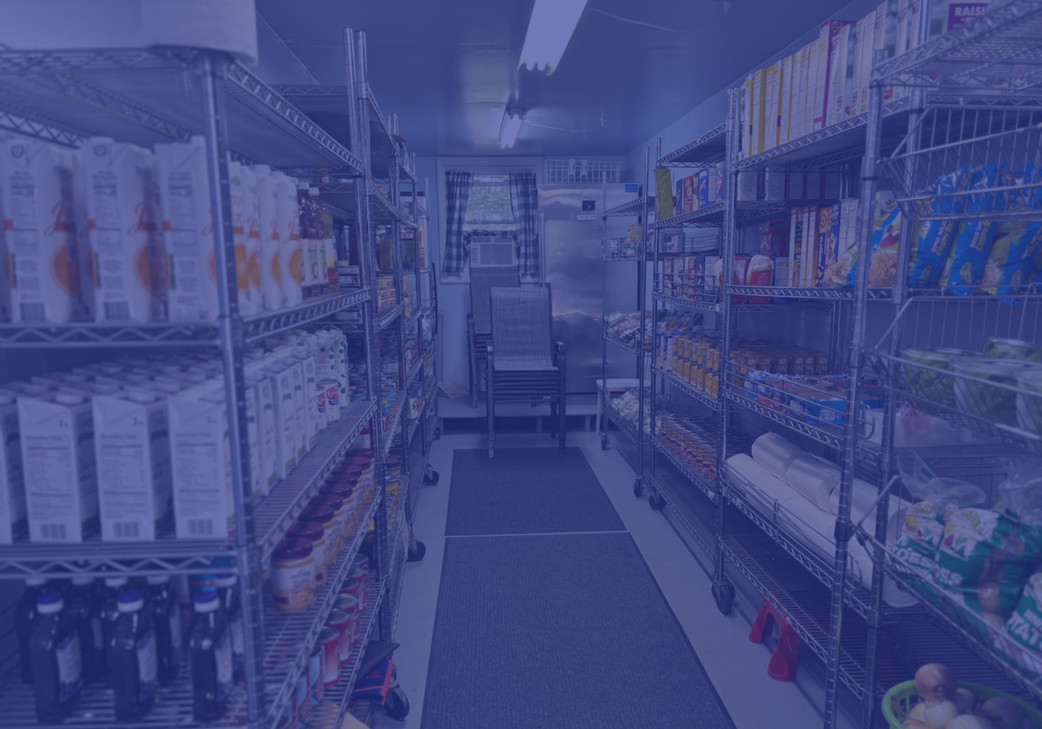 Food pantry shelves stocked with milk cartons, canned goods and packaged food