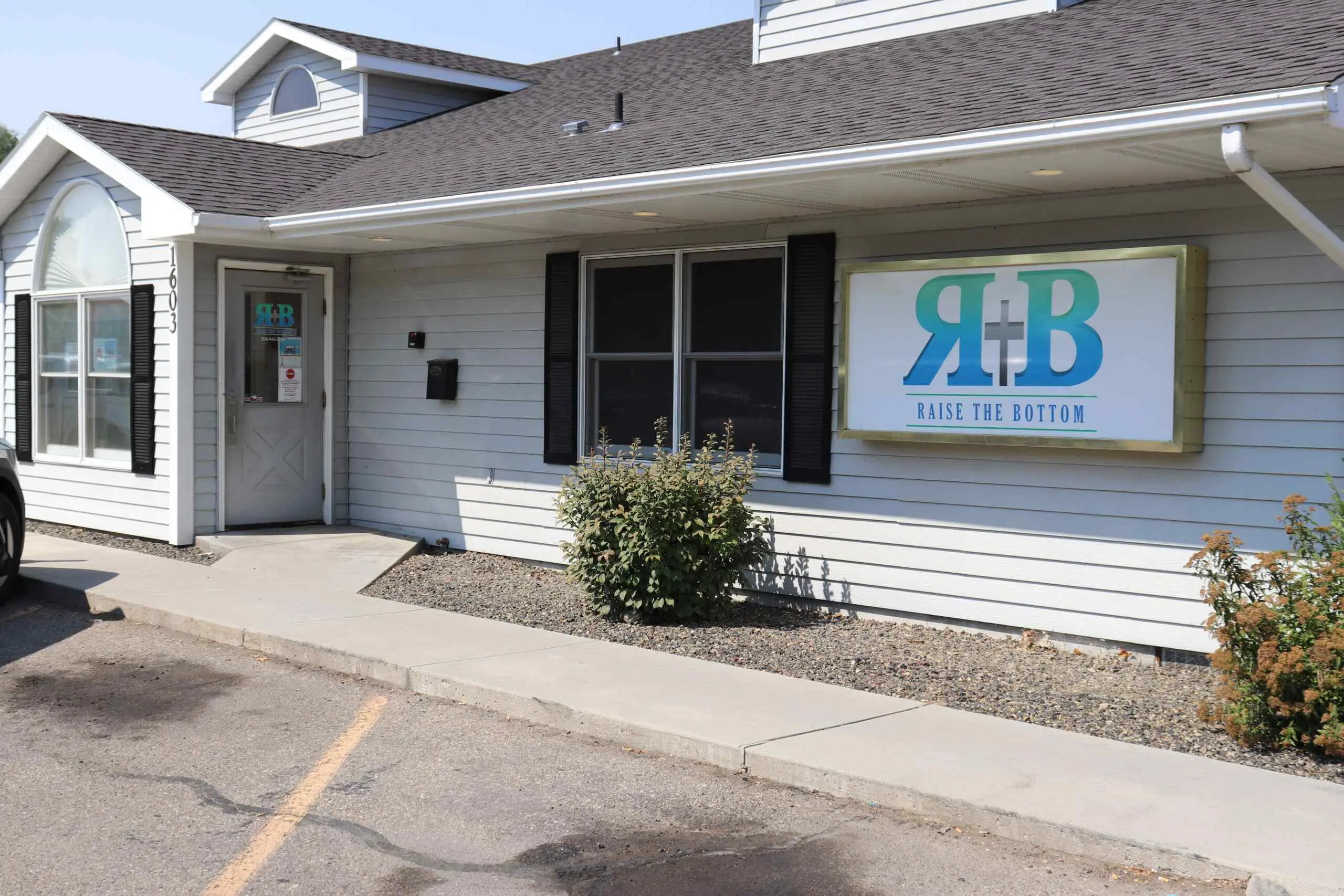Single-story building with a Raise the Bottom sign and address 1603 beside the entrance
