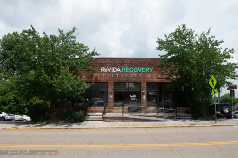 Two-story brick building with a ReVIDA RECOVERY sign and 2001 Highland Ave address