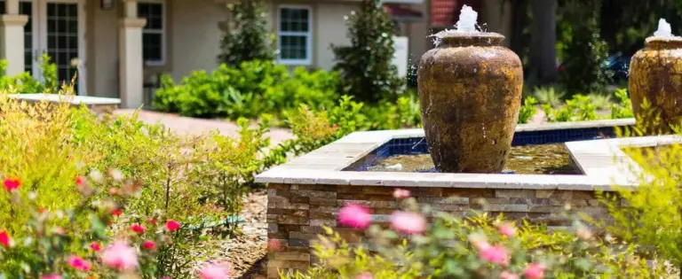 Garden fountains and flowering shrubs in front of the River Oaks Treatment Center entrance walk
