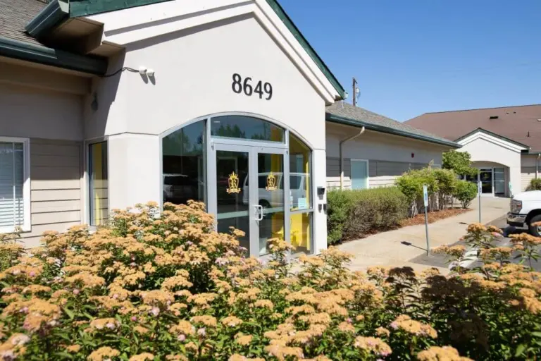 Single-story beige building with address 8649 and gold crown logos on glass entrance doors