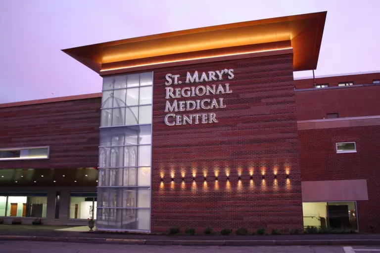 Brick hospital building at dusk with a St. Mary's Regional Medical Center sign above the entrance
