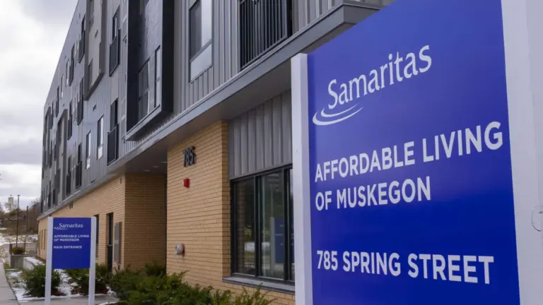 Brick and metal-clad apartment building with a blue Samaritas Affordable Living of Muskegon sign