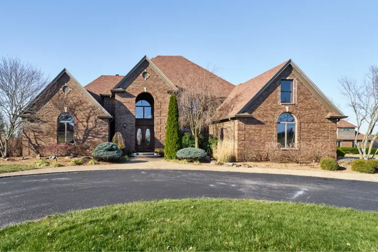 Two-story brick house with arched windows and a circular driveway