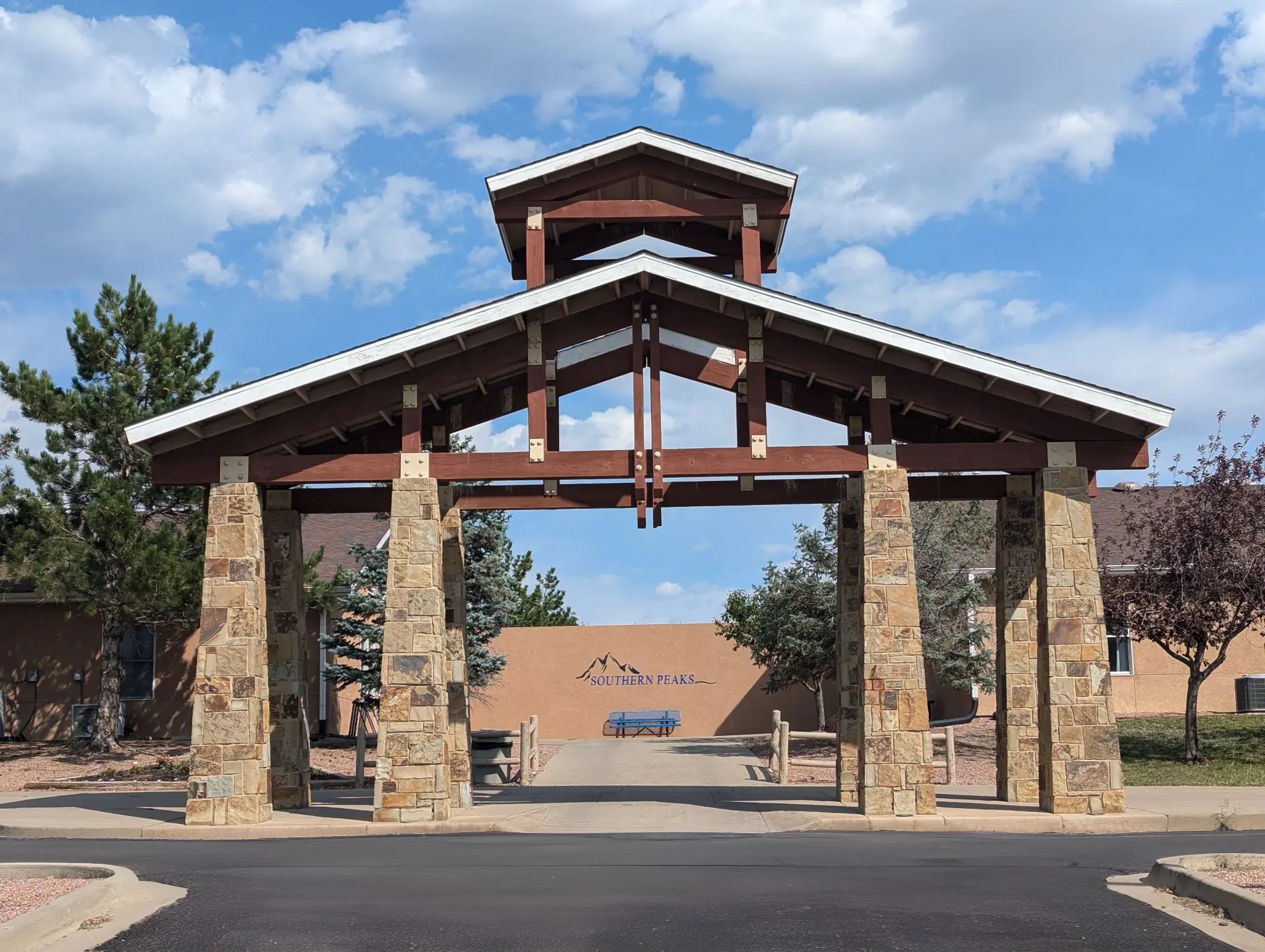Stone and timber entry gateway with a Southern Peaks sign on the wall behind