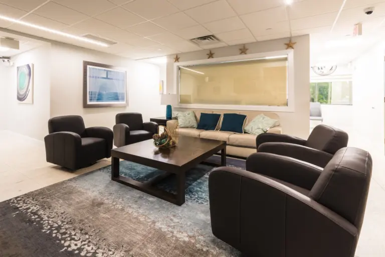 Lounge with leather armchairs, a sofa, and a coffee table in a light, modern room