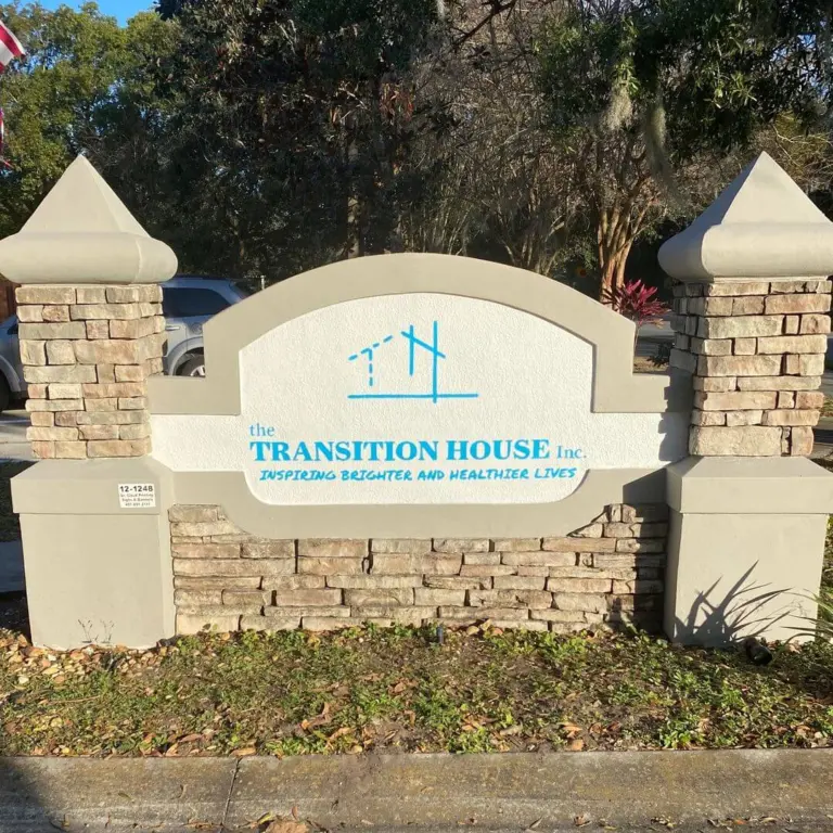 Entrance sign reading the TRANSITION HOUSE Inc. with the tagline Inspiring Brighter and Healthier Lives
