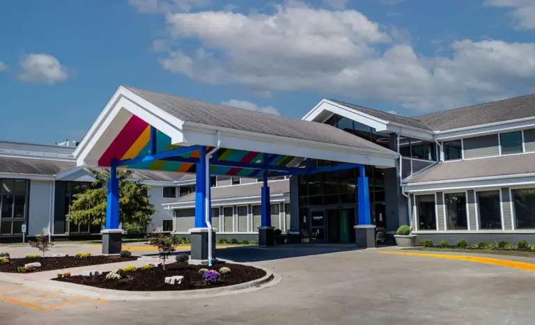 Two-story building with a colorful striped entrance canopy and blue columns