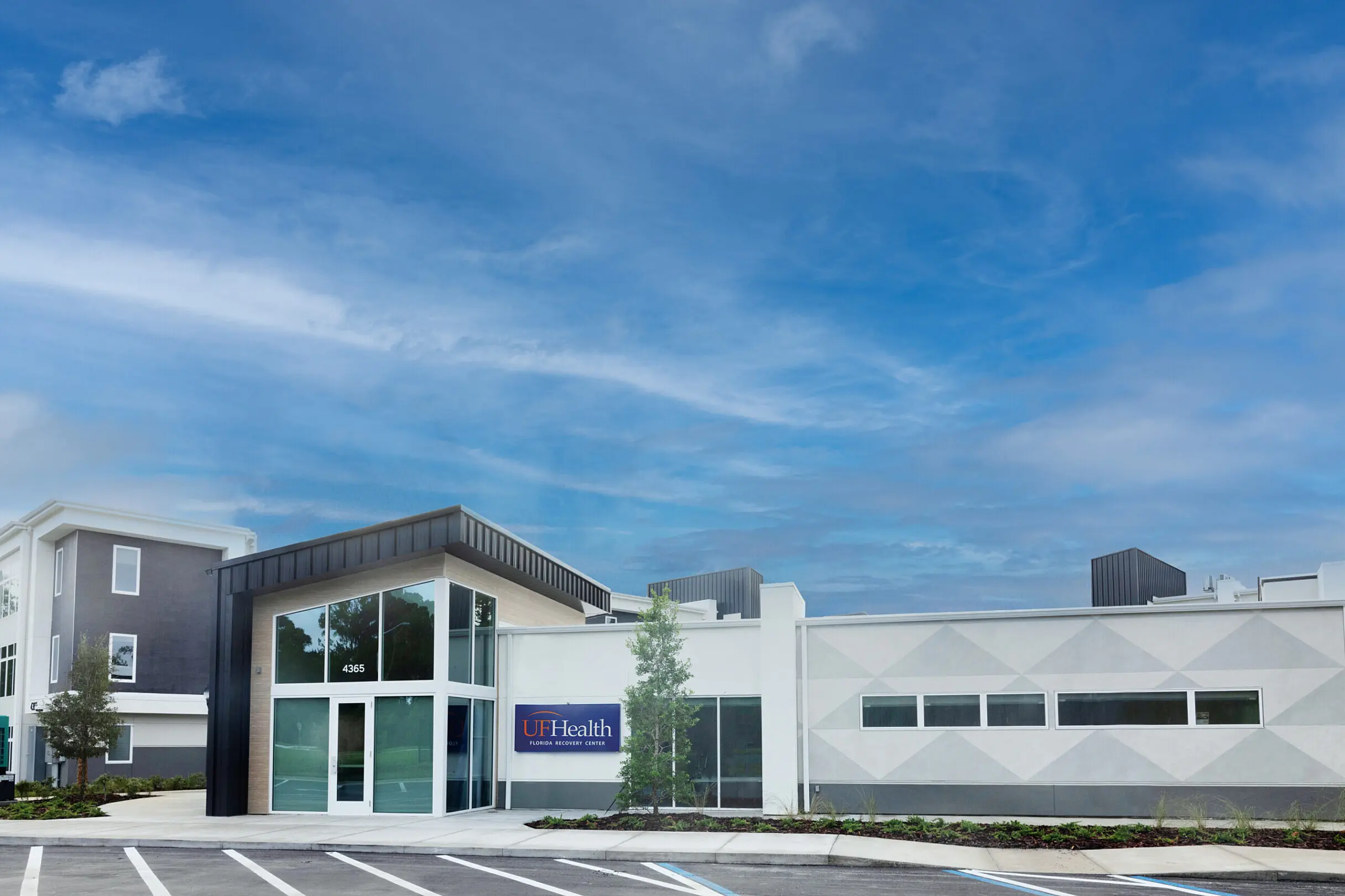 White one-story UF Health Florida Recovery Center building with a blue sign and address 4365 under blue sky