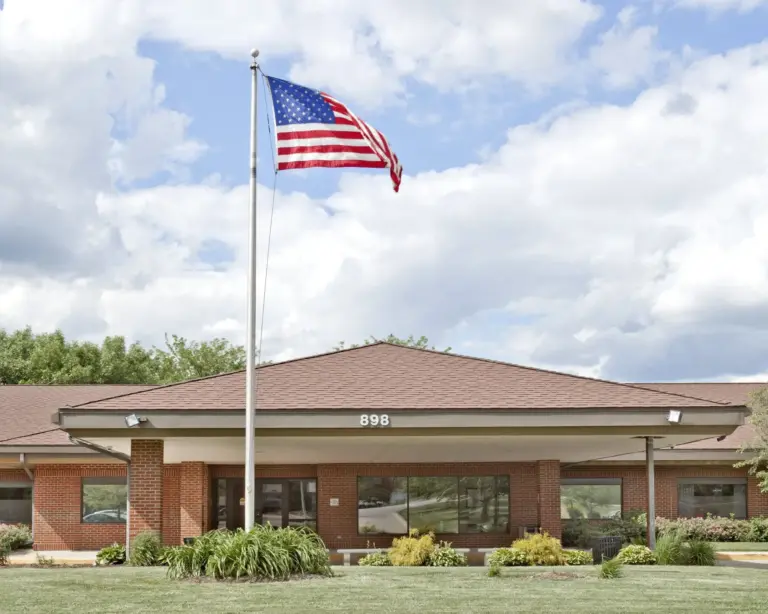 Single-story brick building with a flagpole and the number 898 above the entrance